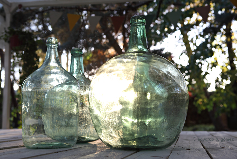 Damajuanas sobre una mesa en un jardín