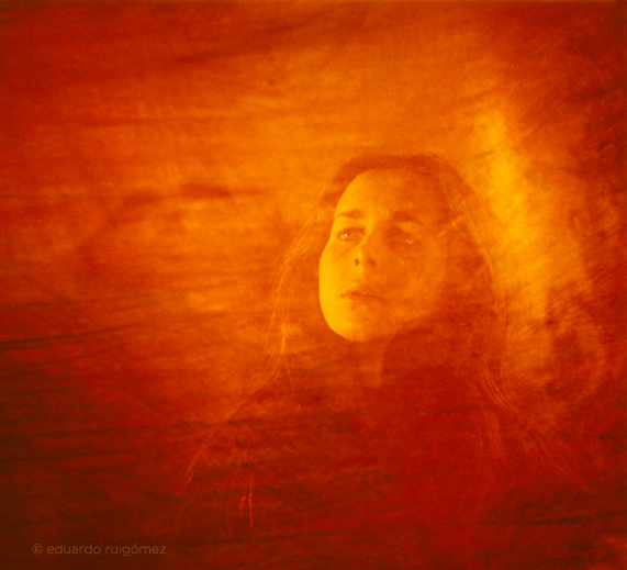 Chica mirando hacia arriba con un fondo rojo.