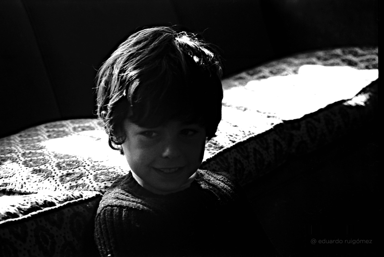 Niño en un sofá a contraluz.