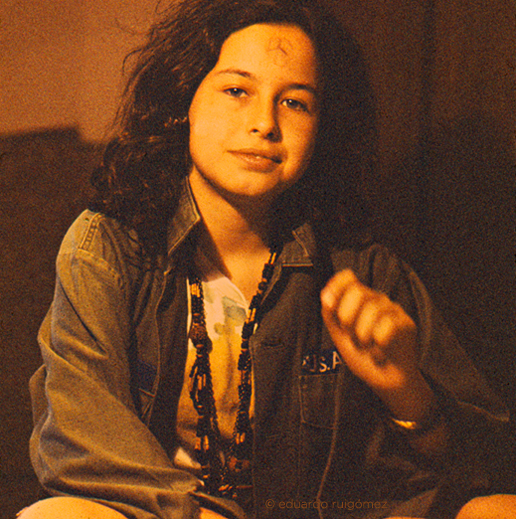 Chica mirando a cámara con el símbolo delpacifismo en la frente.