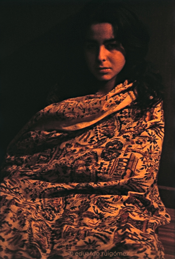 Chica envuelta en una tela india mirando a cámara.