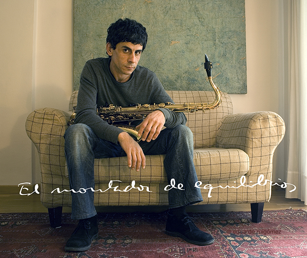 Músico joven con un saxofón sentado en un sofá.