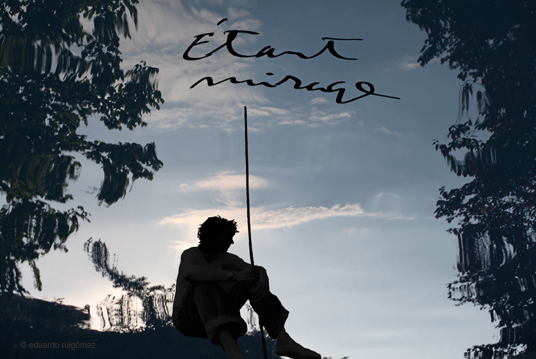 Silueta de un hombre sentado con una vara larga rodeado de un fondo difuso de árboles, agua y cielo con nubes.