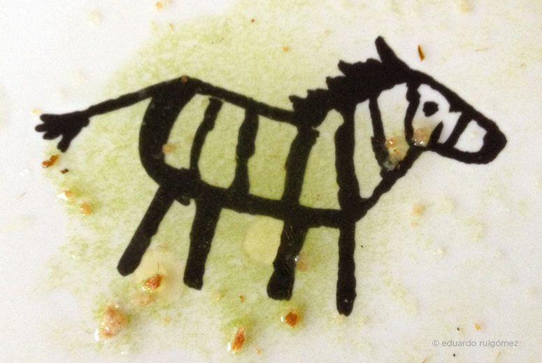 Plato de desayuno con un dibujo de cebra y restos de un kiwi y tomate