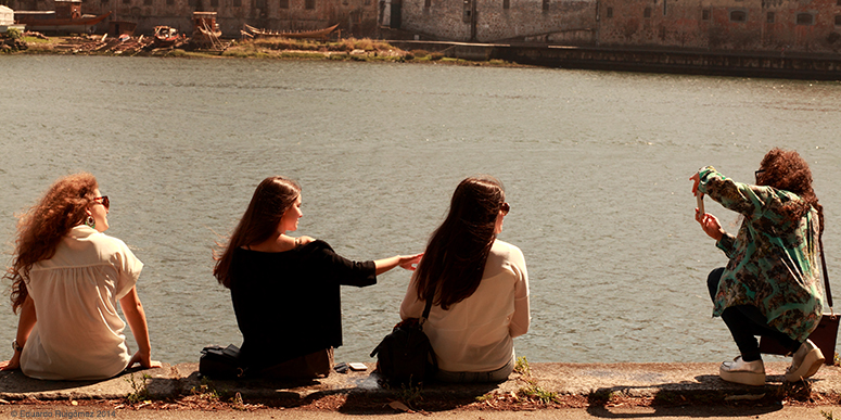 Cuatro muchachas retratándose al borde del río